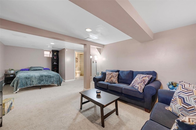 bedroom featuring baseboards, light carpet, and ensuite bath