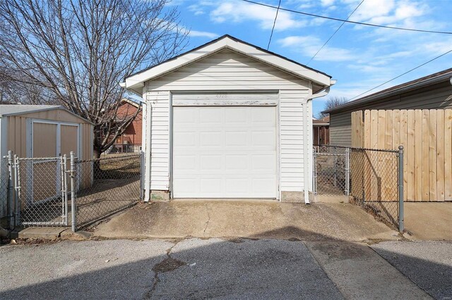 detached garage with a gate and fence