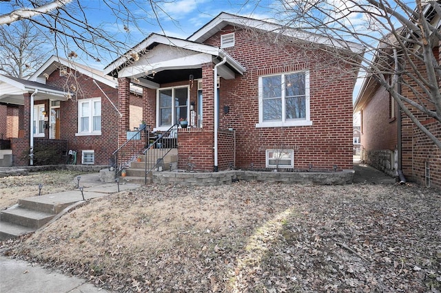 bungalow featuring brick siding