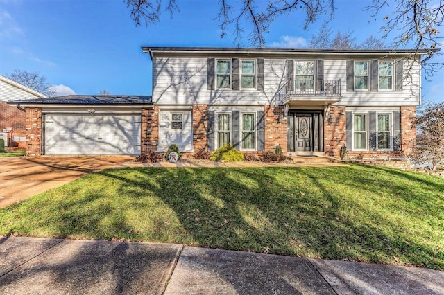 colonial inspired home featuring a front yard, an attached garage, brick siding, and driveway