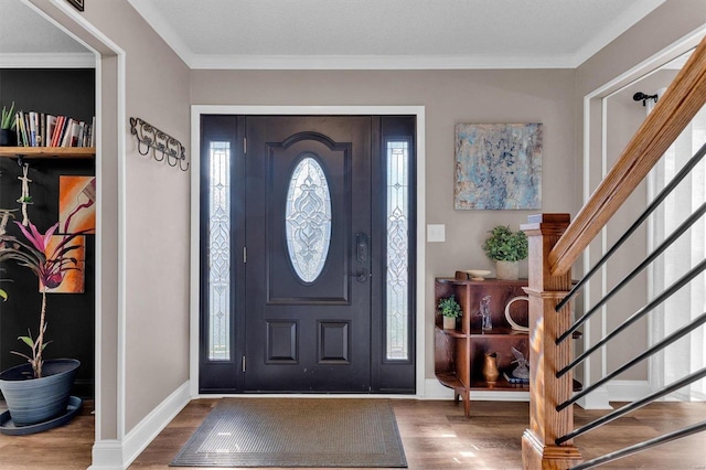 entryway featuring stairs, wood finished floors, baseboards, and ornamental molding