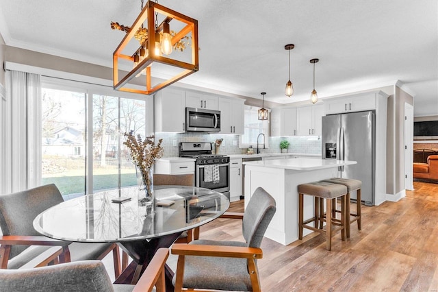 dining room with light wood-style flooring and ornamental molding