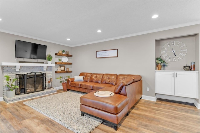 living room featuring crown molding, a fireplace, and light wood-type flooring