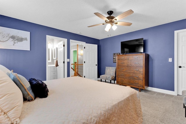 bedroom featuring a ceiling fan, a textured ceiling, ensuite bath, carpet floors, and baseboards