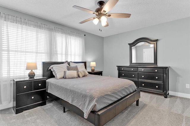 bedroom featuring ceiling fan, baseboards, carpet floors, and a textured ceiling