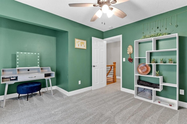 carpeted office featuring baseboards and ceiling fan