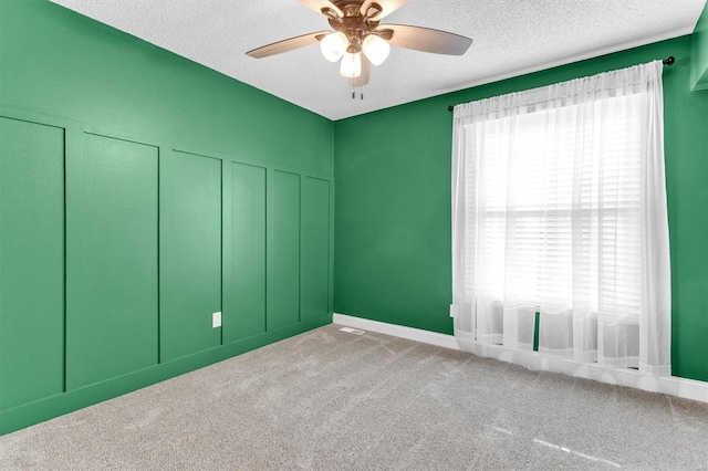 unfurnished room featuring a ceiling fan, carpet floors, and a textured ceiling