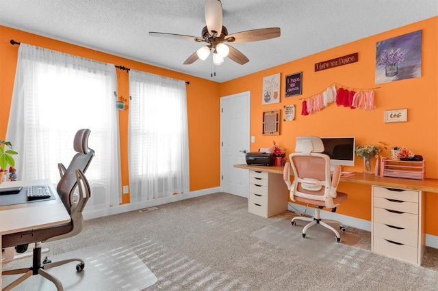 carpeted office with ceiling fan, visible vents, baseboards, and a textured ceiling