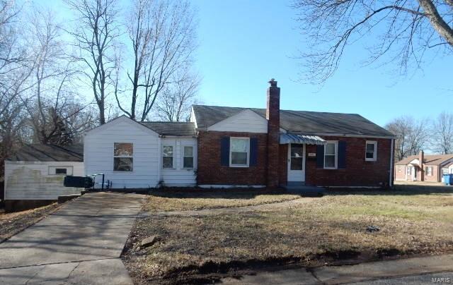 ranch-style home featuring brick siding, a chimney, and a front lawn