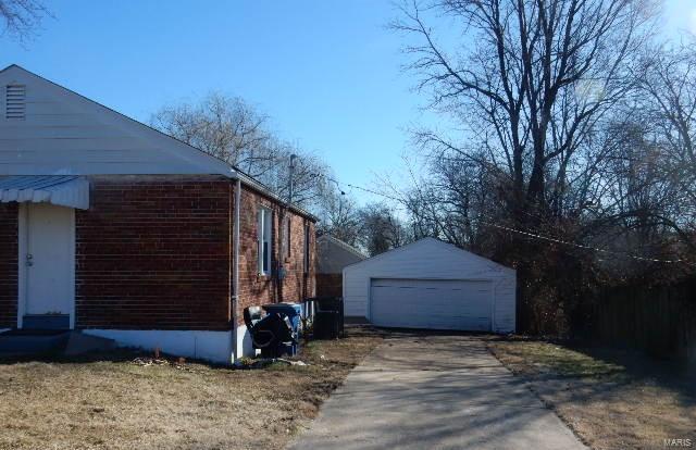 view of side of property with a garage and an outbuilding