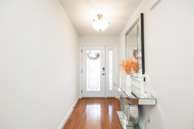 foyer with baseboards and light wood-style floors