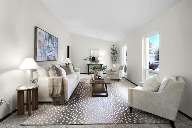 carpeted living room with lofted ceiling and baseboards