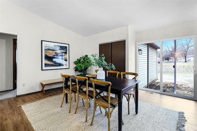 dining space with lofted ceiling and wood finished floors