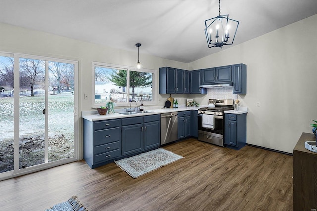 kitchen featuring dark wood finished floors, stainless steel appliances, light countertops, blue cabinetry, and a sink