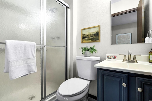 bathroom featuring a stall shower, vanity, and toilet