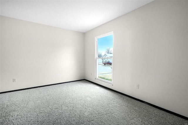 empty room featuring carpet floors and baseboards