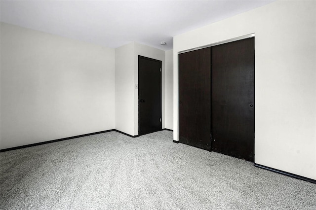 unfurnished bedroom featuring a closet, light colored carpet, and baseboards