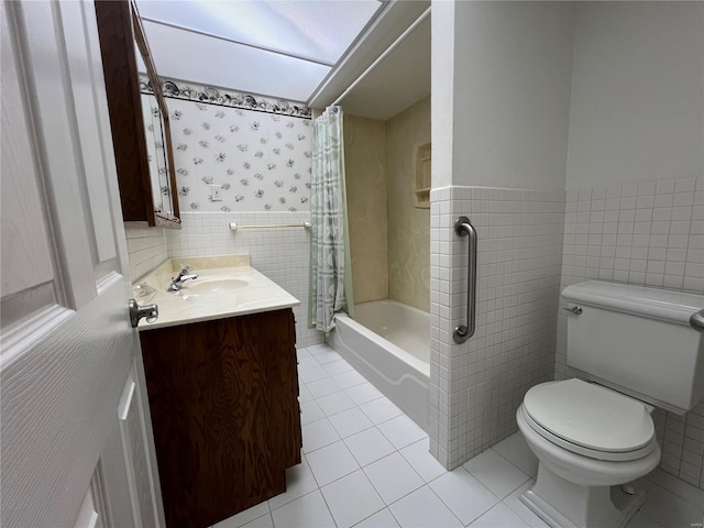 full bathroom featuring tile patterned flooring, toilet, vanity, tile walls, and shower / bath combo with shower curtain