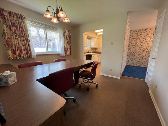 office featuring a chandelier, dark carpet, baseboards, and a sink
