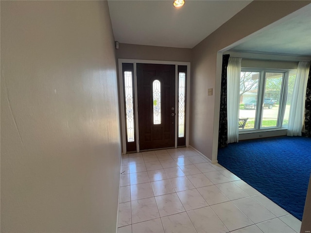 foyer entrance with baseboards and light tile patterned floors