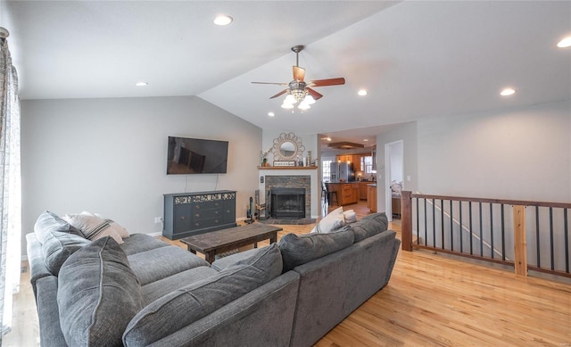 living area featuring recessed lighting, a fireplace, light wood-type flooring, and lofted ceiling