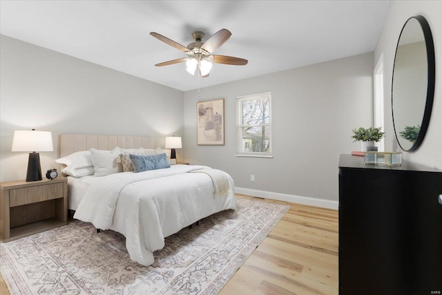 bedroom with baseboards, a ceiling fan, and light wood finished floors