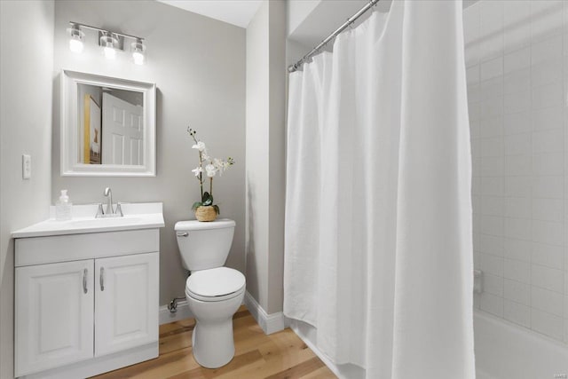 full bath with toilet, vanity, baseboards, and wood finished floors