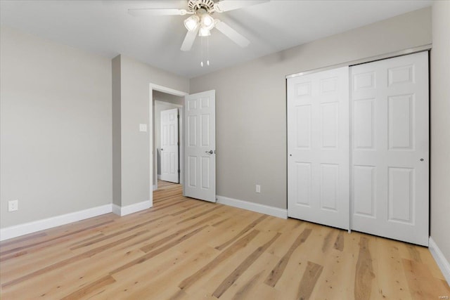 unfurnished bedroom with a closet, baseboards, light wood-style floors, and ceiling fan