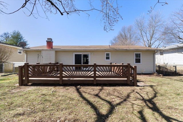 back of house with a yard, a wooden deck, a chimney, and fence