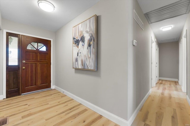 foyer featuring visible vents, baseboards, and light wood-style flooring