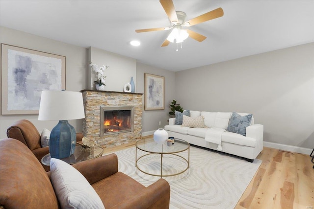 living area with ceiling fan, baseboards, recessed lighting, a fireplace, and wood finished floors