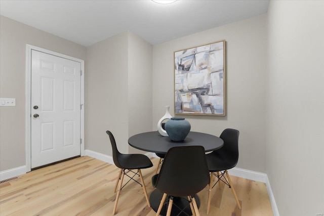 dining area featuring baseboards and light wood-style flooring