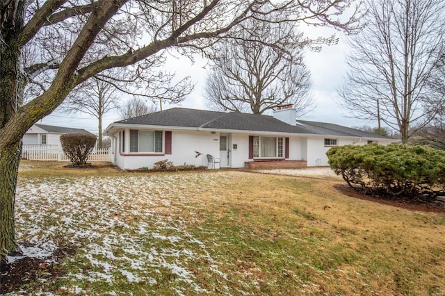 single story home featuring fence, a chimney, and a front lawn