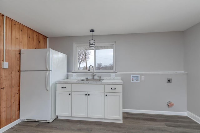 kitchen with dark wood-type flooring, a sink, white cabinets, light countertops, and freestanding refrigerator