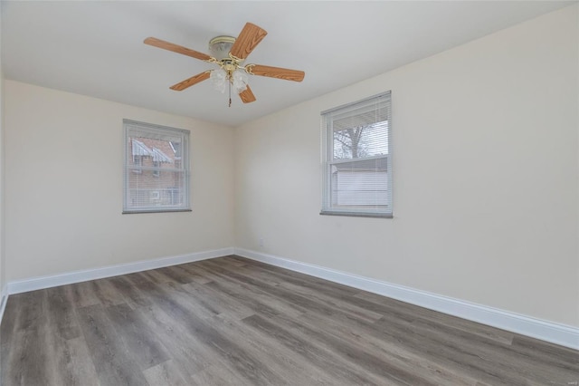 empty room with ceiling fan, wood finished floors, and baseboards