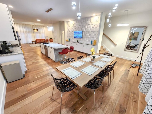 dining space with light wood-style flooring, recessed lighting, stairway, and baseboards