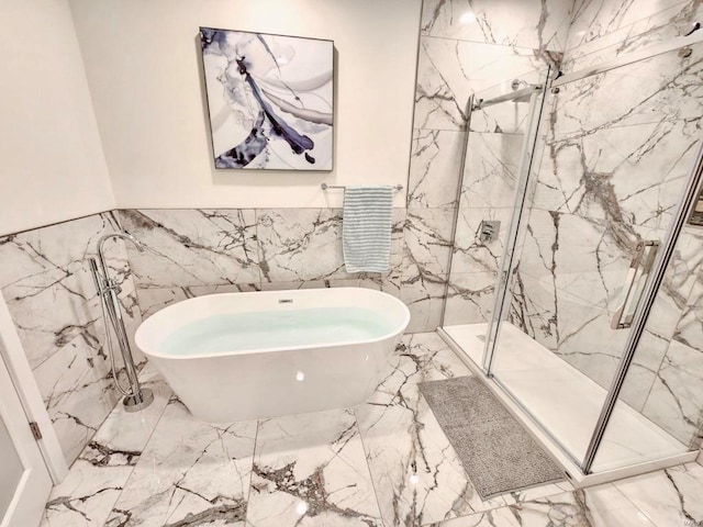 full bath featuring marble finish floor, wainscoting, a soaking tub, and a marble finish shower