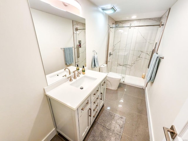 bathroom featuring a marble finish shower, toilet, vanity, baseboards, and tile patterned floors