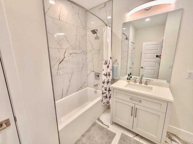 bathroom featuring marble finish floor, shower / bath combo, vanity, and baseboards