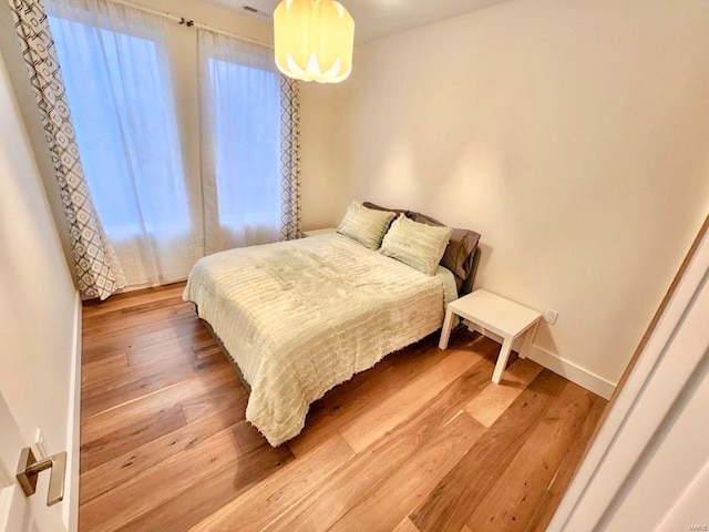 bedroom with baseboards and wood finished floors