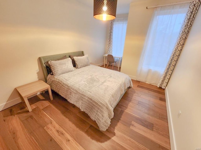 bedroom featuring baseboards and wood finished floors