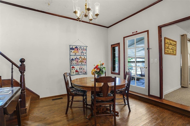 dining room featuring visible vents, crown molding, baseboards, and wood finished floors