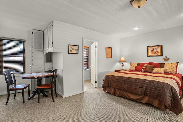 carpeted bedroom with baseboards and a textured ceiling