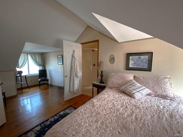 bedroom featuring lofted ceiling and wood finished floors