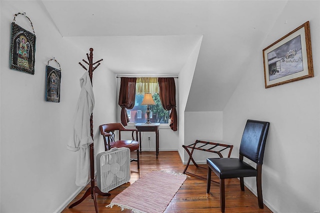 living area featuring lofted ceiling, wood finished floors, and baseboards