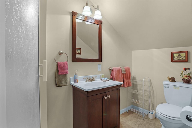 bathroom featuring toilet, lofted ceiling, and vanity