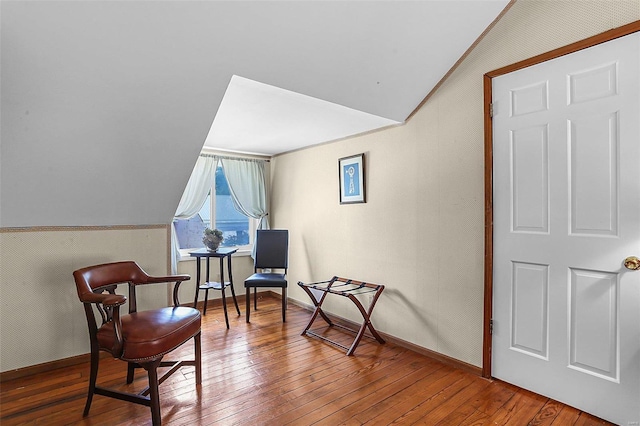 living area with lofted ceiling, wood-type flooring, and baseboards