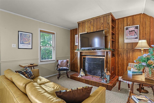 carpeted living room featuring a fireplace with raised hearth, wood walls, baseboards, vaulted ceiling, and ornamental molding