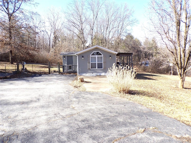 manufactured / mobile home with aphalt driveway and fence