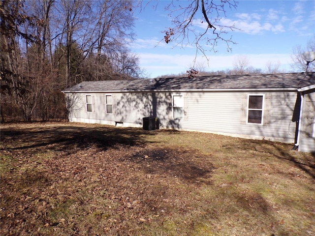 back of house featuring roof with shingles and central air condition unit